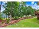 Well-manicured backyard featuring lush green lawn and a mature tree line at 1480 Big Leaf Loop, Apex, NC 27502