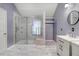 Elegant bathroom featuring a marble floor, glass enclosed shower, and a double vanity with modern fixtures at 1480 Big Leaf Loop, Apex, NC 27502