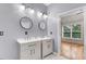 Elegant bathroom featuring dual vanities with modern fixtures, two round mirrors, and lots of natural light at 1480 Big Leaf Loop, Apex, NC 27502