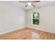 This bedroom features hardwood floors, a ceiling fan, and a window offering a view of the exterior at 1480 Big Leaf Loop, Apex, NC 27502