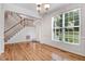 Bright entryway featuring hardwood floors, a staircase, and a large window with natural light at 1480 Big Leaf Loop, Apex, NC 27502