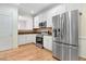 Well-lit kitchen boasts stainless steel appliances, granite countertops, and hardwood floors at 1480 Big Leaf Loop, Apex, NC 27502