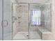 This bathroom features a tiled shower with glass doors, a built in seat, and marble accents at 1480 Big Leaf Loop, Apex, NC 27502