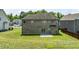 A well-maintained backyard with a brick home, a small concrete patio, and a lush green lawn at 1499 Fireside Ln, Creedmoor, NC 27522