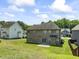 A well-maintained backyard with a brick home, a small concrete patio, and a lush green lawn at 1499 Fireside Ln, Creedmoor, NC 27522
