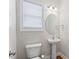 Bright half-bathroom featuring pedestal sink, window, and modern fixtures at 1499 Fireside Ln, Creedmoor, NC 27522