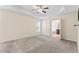 Primary bedroom with carpet flooring, gray walls, and a tray ceiling with a ceiling fan at 1499 Fireside Ln, Creedmoor, NC 27522