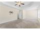 Primary bedroom with carpet flooring, gray walls, and a tray ceiling with a ceiling fan at 1499 Fireside Ln, Creedmoor, NC 27522