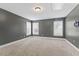 Bedroom with neutral carpet, gray walls, white trim, and three windows at 1499 Fireside Ln, Creedmoor, NC 27522