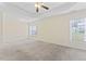 Primary bedroom with a tray ceiling, ceiling fan, and carpeted floor with two windows at 1499 Fireside Ln, Creedmoor, NC 27522