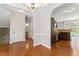 Open dining room with hardwood floors, chandelier, and arched doorway to kitchen and other rooms at 1499 Fireside Ln, Creedmoor, NC 27522