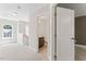 Hallway and partial bathroom are well-lit and features carpeted flooring with an arched window and neutral paint at 1499 Fireside Ln, Creedmoor, NC 27522