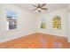 Bedroom with hardwood floors, three windows, and a ceiling fan at 15 Treviso Pl, Durham, NC 27707