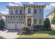 Two-story home featuring a two-car garage, balcony, arched windows, and manicured lawn at 15 Treviso Pl, Durham, NC 27707