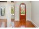 Bright foyer featuring hardwood floors, decorative front door, and arched windows allowing natural light at 15 Treviso Pl, Durham, NC 27707