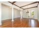 Spacious living room with hardwood floors, beamed ceiling, and grand columns perfect for entertaining guests at 15 Treviso Pl, Durham, NC 27707
