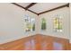 Bright living room showcases hardwood floors and large windows offering views of the lush, green landscape at 15 Treviso Pl, Durham, NC 27707