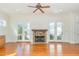 Cozy living room showcasing a stone fireplace, hardwood floors, French doors, and abundant natural light at 15 Treviso Pl, Durham, NC 27707