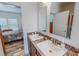 Bathroom featuring double sinks, granite counters, and a view into the adjacent bedroom at 153 Bywood Dr, Roxboro, NC 27573