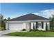 A charming white home with black accents, an attached garage, and a well-manicured lawn in Matthews Ridge community at 16 Vale Spring Ln, Lillington, NC 27546