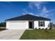 Charming single-story home with a two-car garage, manicured lawn, and a classic black and white color scheme at 16 Vale Spring Ln, Lillington, NC 27546