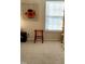 Bright bedroom featuring a window with blinds, a stylish accent chair, and neutral carpeting at 1633 Snow Mass Way, Durham, NC 27713