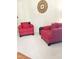 Comfortable living room with bright red armchairs, neutral carpet, and decorative wall clock at 1633 Snow Mass Way, Durham, NC 27713
