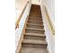 Carpeted staircase with wooden handrails and white spindles leading to the upper level at 1633 Snow Mass Way, Durham, NC 27713