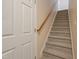 Carpeted staircase with wooden handrail and a white door to the side at 169 Clearwater Harbor Hbr, Sanford, NC 27332