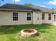 Backyard with lush green grass and brick fire pit at 1728 E Honey Springs Ave, Fuquay Varina, NC 27526