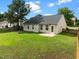 Backyard with green grass, a fire pit, patio, and fenced perimeter at 1728 E Honey Springs Ave, Fuquay Varina, NC 27526