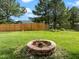 Fenced backyard with lush green grass and brick fire pit at 1728 E Honey Springs Ave, Fuquay Varina, NC 27526