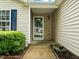 Inviting front entrance with a storm door, tidy landscaping and a window with a blue shutter at 1728 E Honey Springs Ave, Fuquay Varina, NC 27526