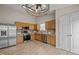 Well-lit kitchen with stainless steel appliances, light wood cabinets, and stylish light fixture at 1728 E Honey Springs Ave, Fuquay Varina, NC 27526