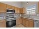 Modern kitchen with stainless steel appliances and light wood cabinets at 1728 E Honey Springs Ave, Fuquay Varina, NC 27526