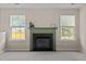 Cozy living room featuring a fireplace and large windows for natural light at 1728 E Honey Springs Ave, Fuquay Varina, NC 27526