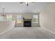 Sunlit living area featuring neutral walls, comfortable carpet and fireplace at 1728 E Honey Springs Ave, Fuquay Varina, NC 27526