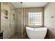 Modern bathroom featuring a glass enclosed shower, soaking tub, and neutral tiling at 18 Gwendolyn Cir, Durham, NC 27703