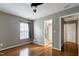 Bedroom featuring hardwood floors, neutral walls, a ceiling fan, and multiple doorways at 18 Gwendolyn Cir, Durham, NC 27703