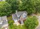 Aerial view of the well-maintained gray home with an attached garage and lush green surroundings at 205 Town Creek Dr, Cary, NC 27519