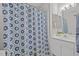 Well-lit bathroom featuring a patterned shower curtain, a white vanity, and decorative mirror at 205 Town Creek Dr, Cary, NC 27519