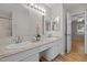 Bathroom with double sink vanity, granite countertops, and an open doorway leading to a bedroom at 205 Town Creek Dr, Cary, NC 27519