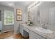 Bathroom with double sink vanity, granite countertops, decorative mirrors, and hardwood floors at 205 Town Creek Dr, Cary, NC 27519