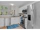 Bright kitchen features stainless steel appliances, white cabinets, granite counters and hardwood flooring at 205 Town Creek Dr, Cary, NC 27519
