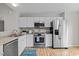 Modern kitchen boasts stainless steel appliances, granite countertops, white cabinets, and wood floors at 205 Town Creek Dr, Cary, NC 27519