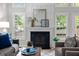 Elegant living room featuring fireplace, large windows, and stylish decor with ample seating at 205 Town Creek Dr, Cary, NC 27519
