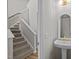 Cozy powder room with pedestal sink and a view of the staircase with carpet at 205 Town Creek Dr, Cary, NC 27519