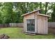 Backyard shed with string lights and a fire pit, surrounded by greenery at 212 E Rockway St, Durham, NC 27704