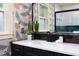 Charming bathroom offers a white countertop on a black vanity with a modern mirror and a decorative plant at 212 E Rockway St, Durham, NC 27704