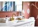 Modern bathroom featuring a white countertop, a gold faucet, a decorative orchid, and unique wall decor at 212 E Rockway St, Durham, NC 27704